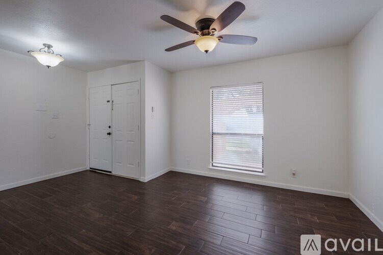 A room with a ceiling fan and a door.
