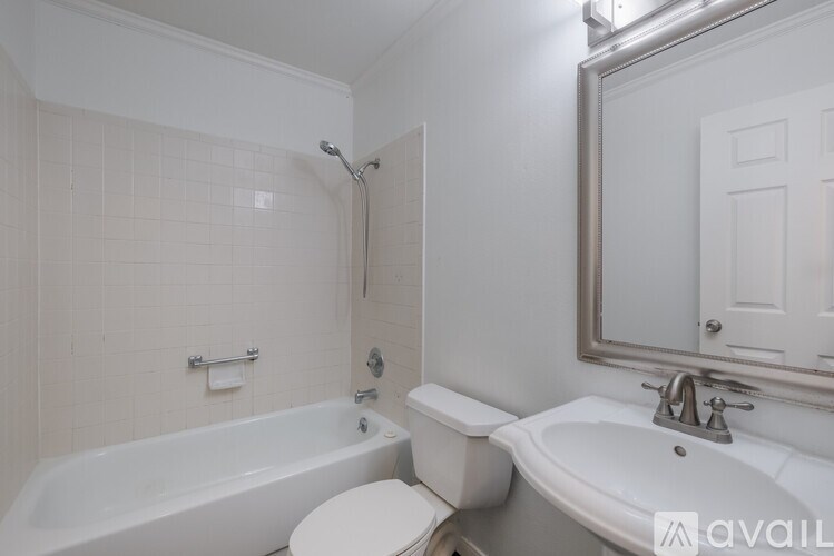 A white bathroom with a tub, toilet, and sink.