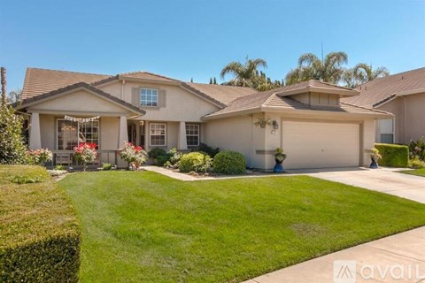 A house with a well-maintained lawn and a clear sky.