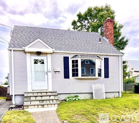 A small house with a white door and a window with blue shutters.