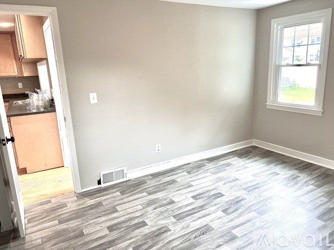 A room with a grey floor and a window.
