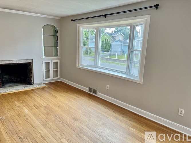 A room with a fireplace and a large window.