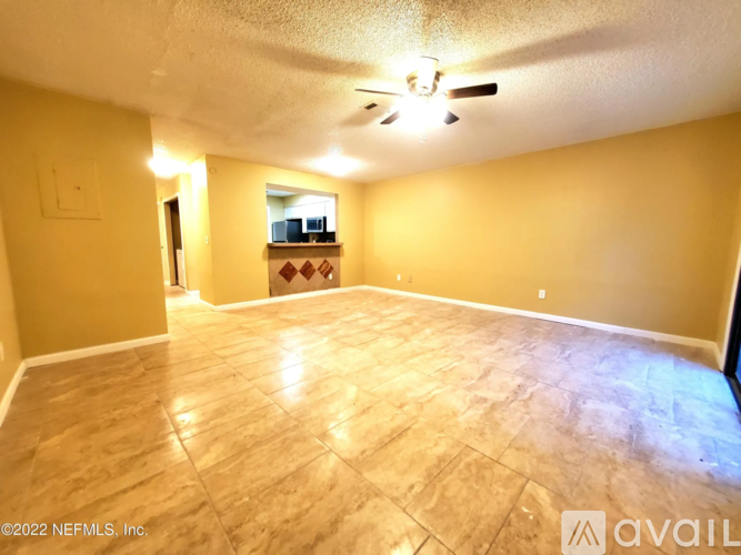 A spacious room with a ceiling fan and a wooden floor.