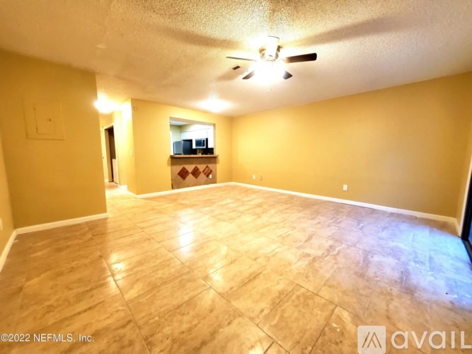 A spacious room with a ceiling fan and a wooden floor.