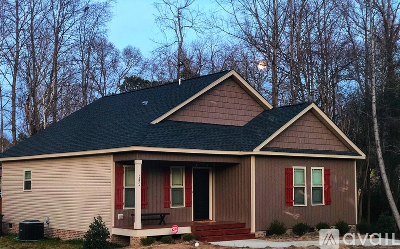 A house with a porch and a garage door is for sale.