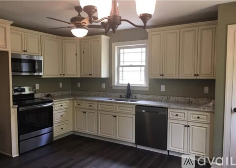 A kitchen with a fan and a window.