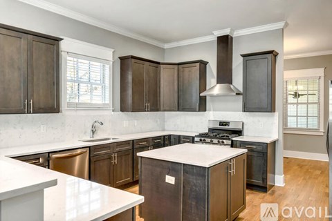 A kitchen with dark brown cabinets and a white countertop.