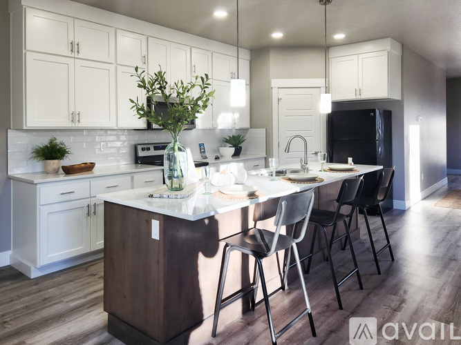 A modern kitchen with a large island and white cabinets.