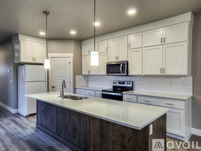 A kitchen with white cabinets and a wooden island.