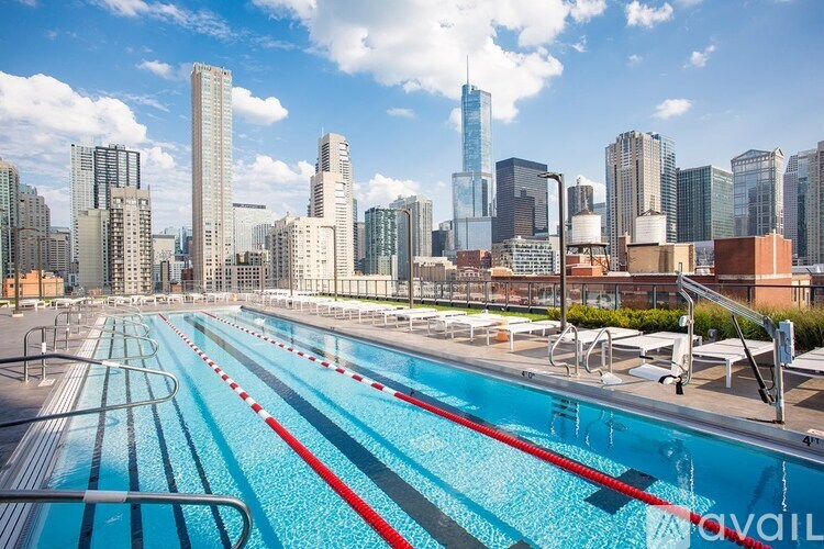 A swimming pool with red lane dividers in front of a city skyline.