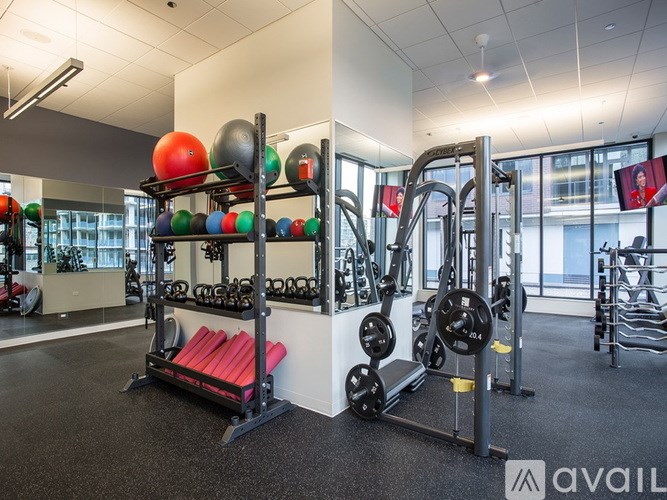 A gym with a variety of equipment including weights and a bench.