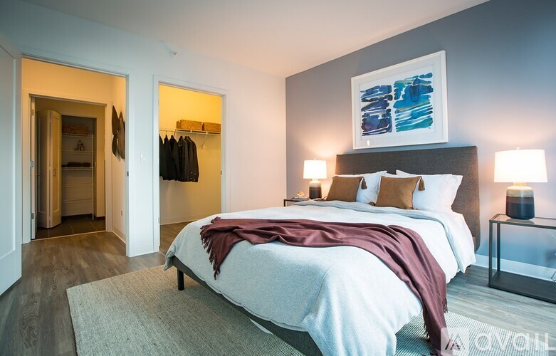 A bedroom with a large bed and a painting on the wall.