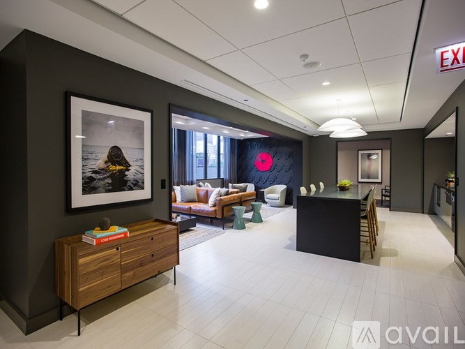 A living room with a black couch and a wooden cabinet.