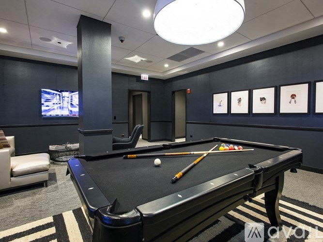 A pool table with a cue and balls is in the center of the room.
