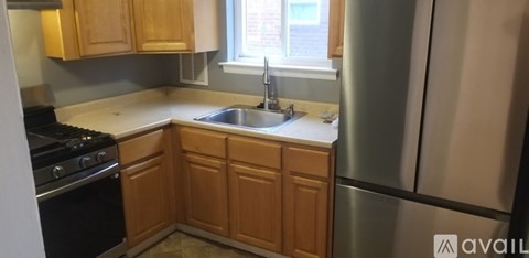 A kitchen with wooden cabinets and a stainless steel refrigerator.