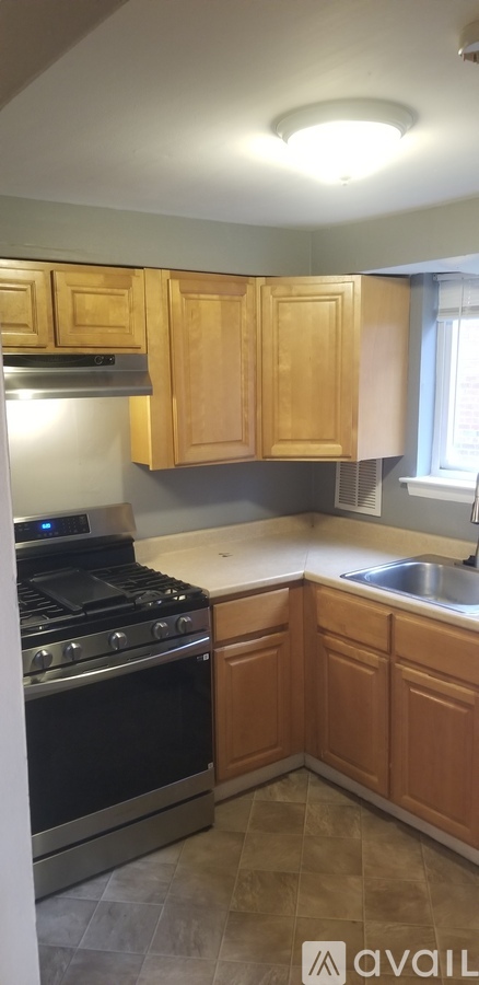 A kitchen with wooden cabinets and a black stove top oven.