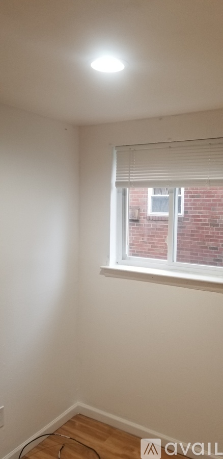 A room with a window and a wooden floor.