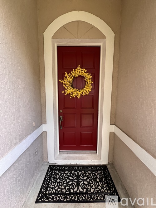A red door is on the right side of a hallway.