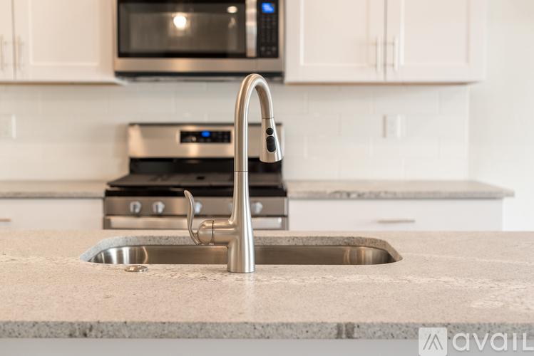A kitchen with a sink and a stove top.