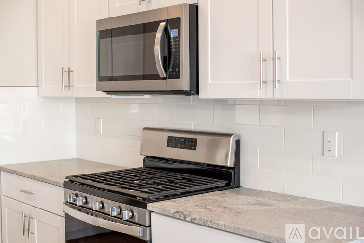 A modern kitchen with a stainless steel oven and microwave above a stove.