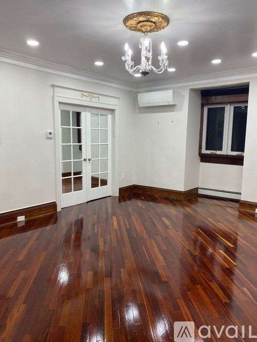 A room with wooden floors and a chandelier.