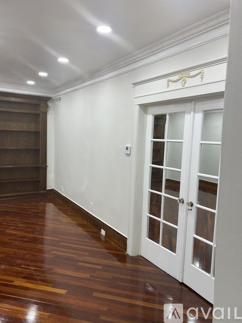 A room with a white door and a wooden floor.