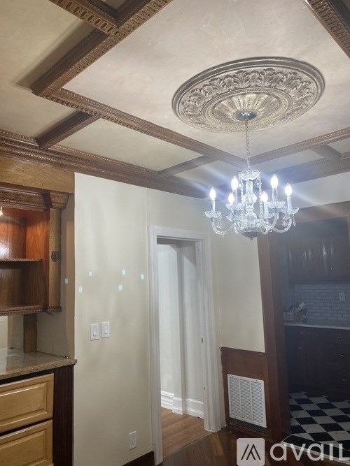 A chandelier hangs from a ceiling with a decorative medallion.