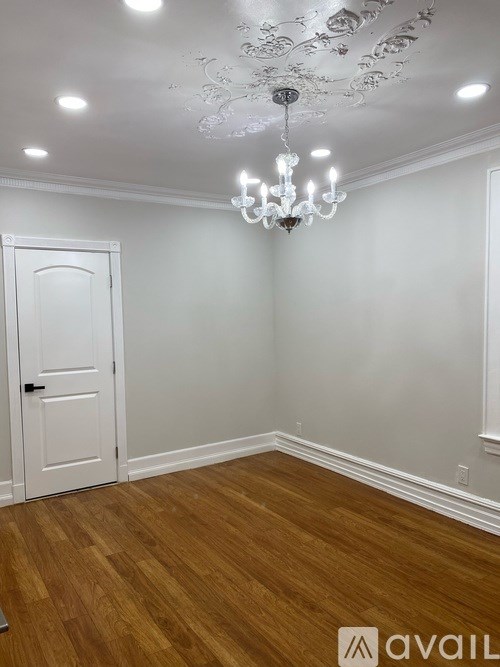 A room with a wooden floor and a chandelier.