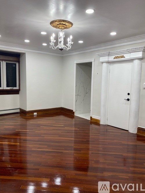 A room with a wooden floor and a chandelier.