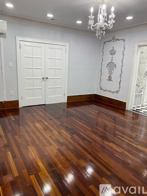 A room with a wooden floor and a chandelier.