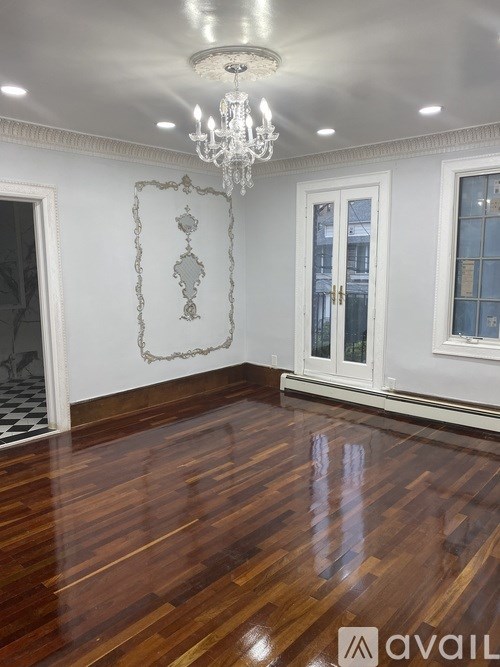 A room with wooden floors and a chandelier.