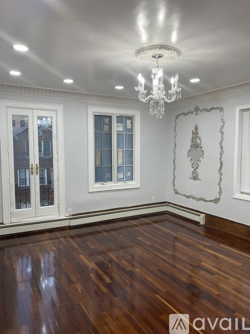 A room with wooden floors and a chandelier.
