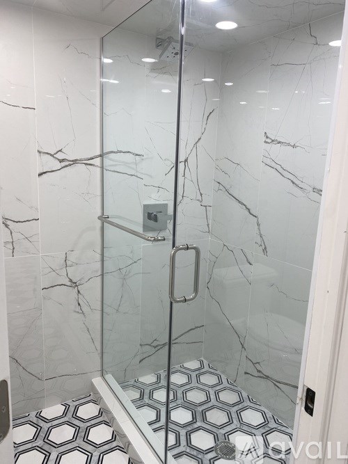 A marble tiled bathroom with a hexagonal tile floor.