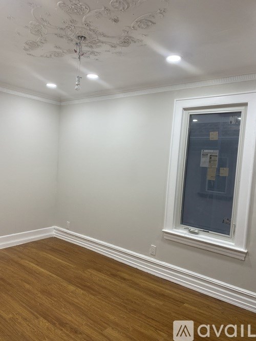 A room with a window and wooden flooring.