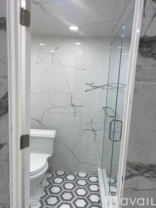 A bathroom with a toilet and a glass shower door.
