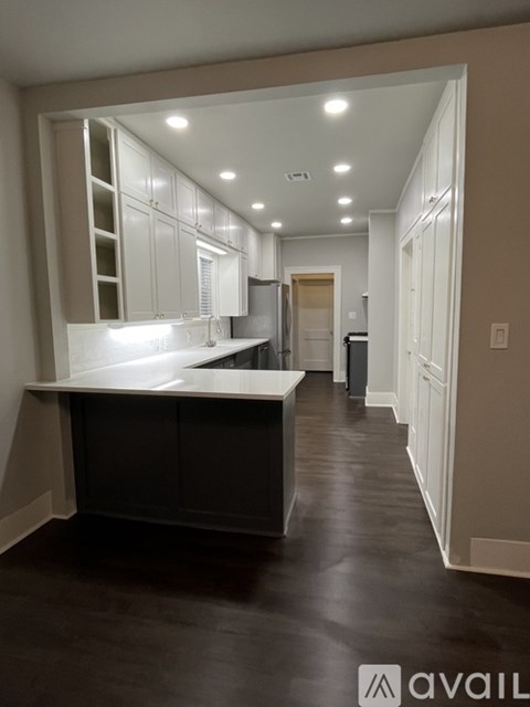 A kitchen with white cabinets and a dark countertop.