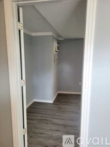 A hallway with a white door on the left and a white door on the right.