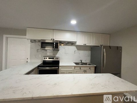 A kitchen with a marble countertop and stainless steel appliances.