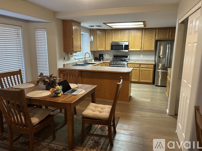 A kitchen with wooden cabinets and a dining table with chairs.