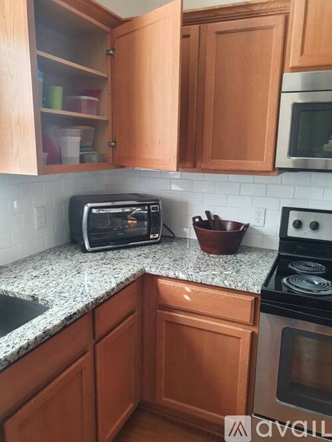 A kitchen with wooden cabinets and a granite countertop.