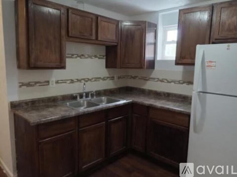 A kitchen with brown cabinets and a white fridge.