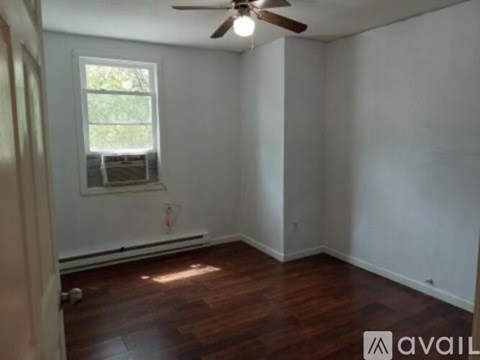 A room with a ceiling fan and a window.
