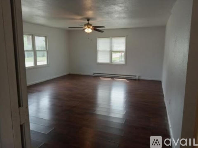A room with wooden flooring and a ceiling fan.