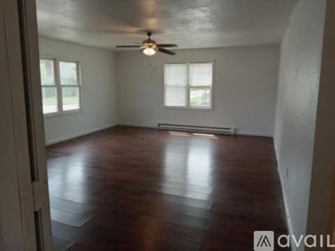 A room with wooden flooring and a ceiling fan.