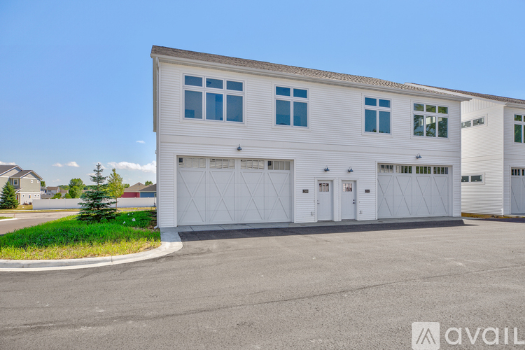 A large white building with a garage door is in the foreground.