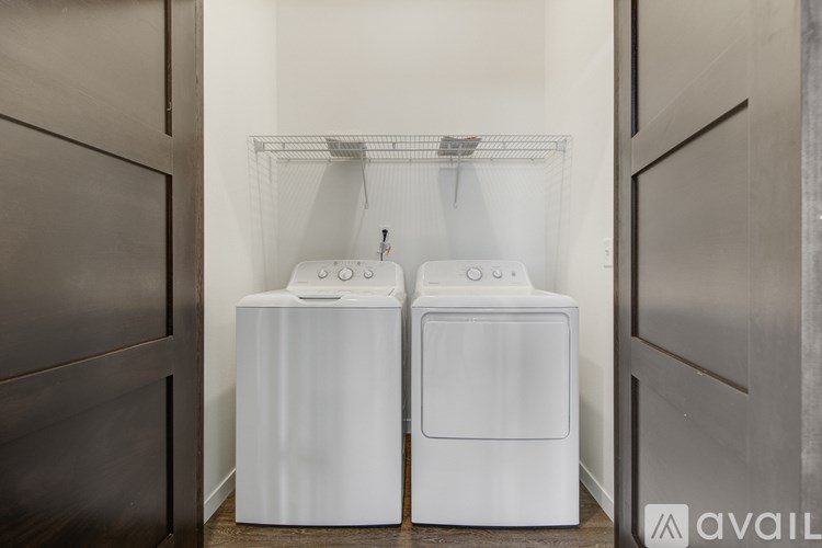 Two white front load washing machines in a laundry room.