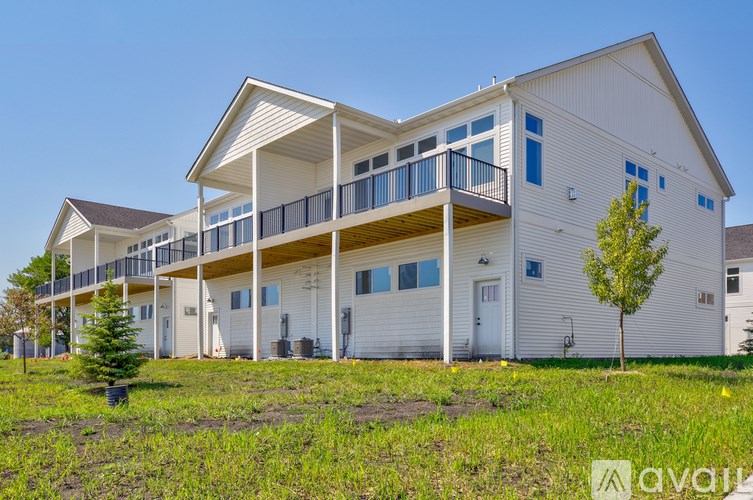 A white two-story house with a balcony on the second floor.