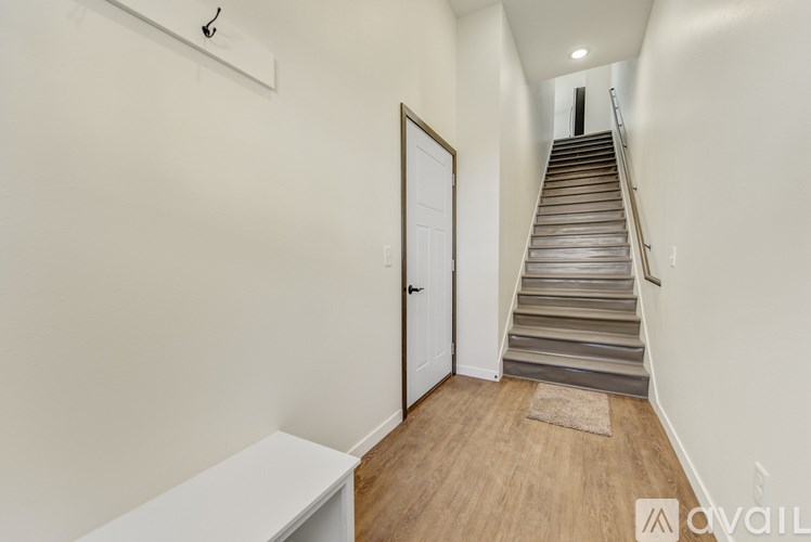 A staircase with a white door at the bottom.