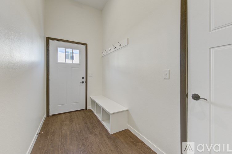 A hallway with a bench and a door.