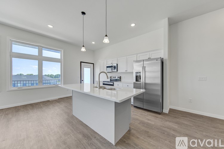 A modern kitchen with a large island and stainless steel appliances.